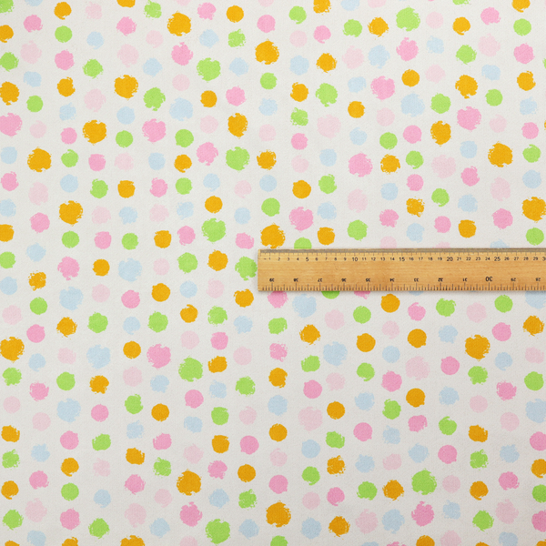A whimsical fabric pattern featuring scattered painterly dots in soft shades of pink, yellow, lime green, and light blue on a white background.