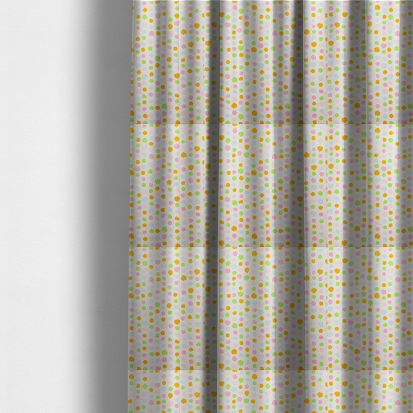 The fabric used to create these made-to-measure curtains is a whimsical fabric pattern featuring scattered painterly dots in soft shades of pink, yellow, lime green, and light blue on a white background.