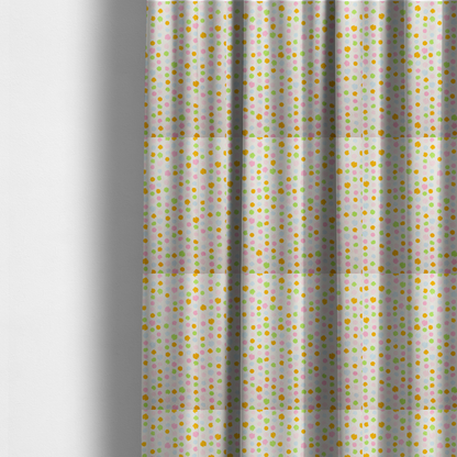 The fabric used to create these made-to-measure curtains is a whimsical fabric pattern featuring scattered painterly dots in soft shades of pink, yellow, lime green, and light blue on a white background.