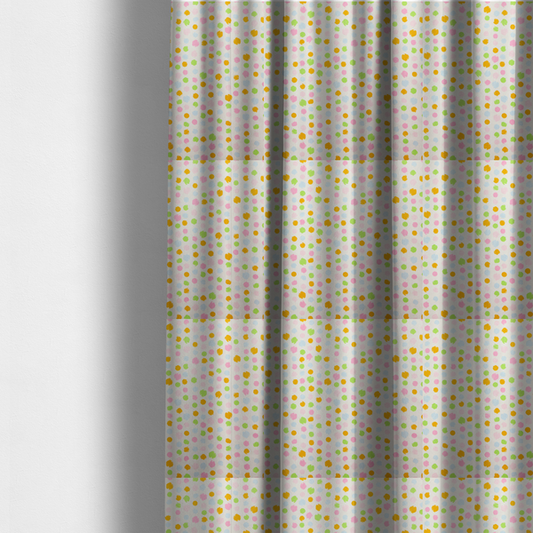 The fabric used to create these made-to-measure curtains is a whimsical fabric pattern featuring scattered painterly dots in soft shades of pink, yellow, lime green, and light blue on a white background.