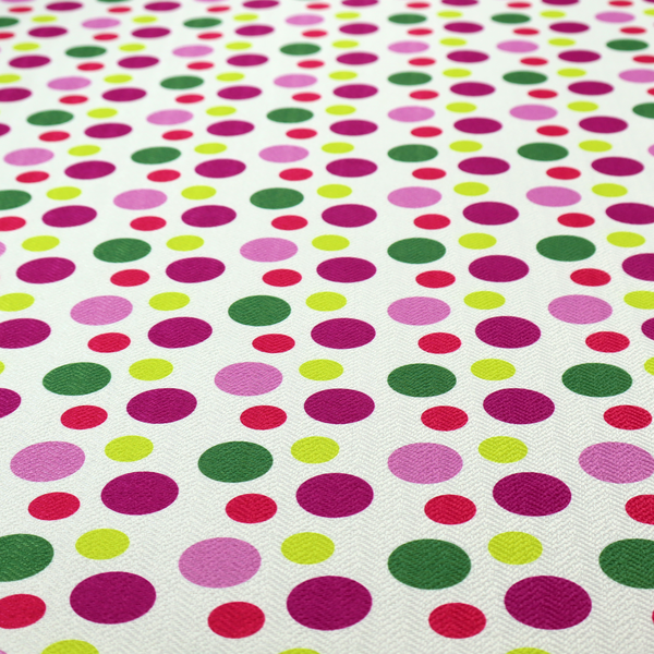 A playful fabric pattern featuring neat vertical rows of alternating polka dots in shades of magenta, pink, green, and lime on a white background.