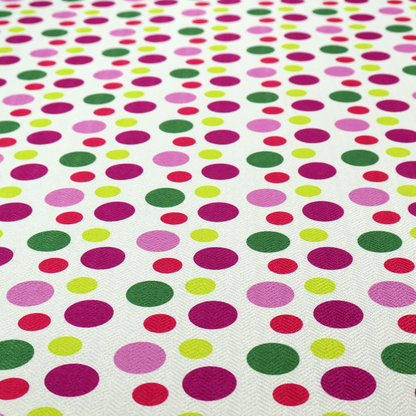 A playful fabric pattern featuring neat vertical rows of alternating polka dots in shades of magenta, pink, green, and lime on a white background.