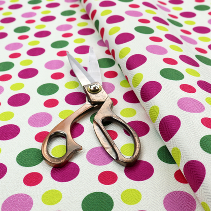 A playful fabric pattern featuring neat vertical rows of alternating polka dots in shades of magenta, pink, green, and lime on a white background.