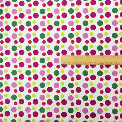 A playful fabric pattern featuring neat vertical rows of alternating polka dots in shades of magenta, pink, green, and lime on a white background.