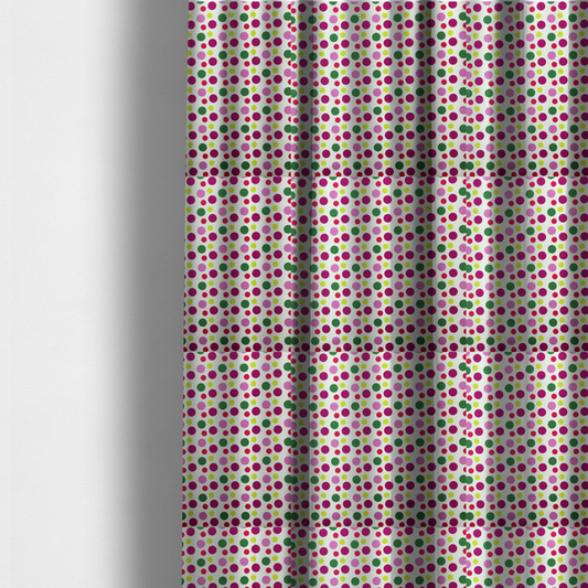 The fabric used to create these made-to-measure curtains is a  playful fabric pattern featuring neat vertical rows of alternating polka dots in shades of magenta, pink, green, and lime on a white background.