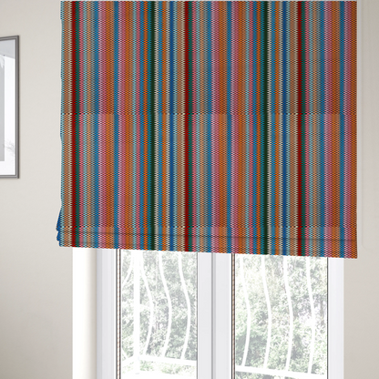 the fabric used to create these Roman blinds is a vibrant fabric pattern featuring tight vertical rows of colourful zigzag lines in shades of orange, pink, blue, red, green, and beige.