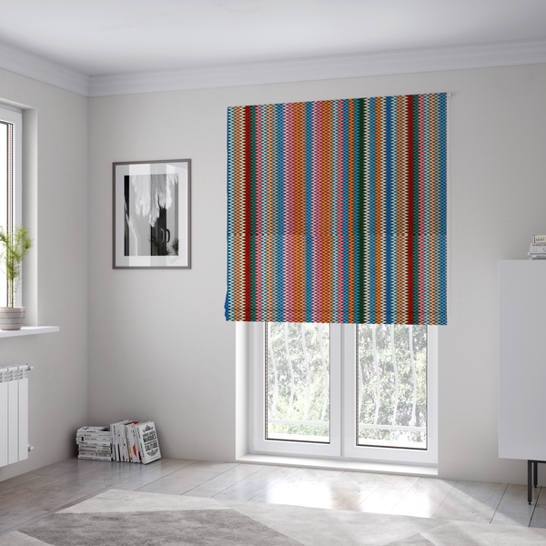 the fabric used to create these Roman blinds is a vibrant fabric pattern featuring tight vertical rows of colourful zigzag lines in shades of orange, pink, blue, red, green, and beige.