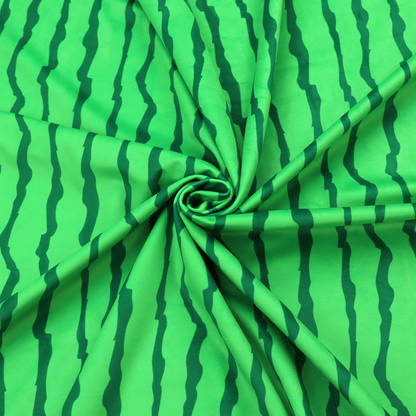A playful fabric pattern featuring vertical wavy dark green stripes running across a bright green background.