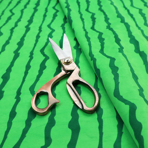 A playful fabric pattern featuring vertical wavy dark green stripes running across a bright green background.