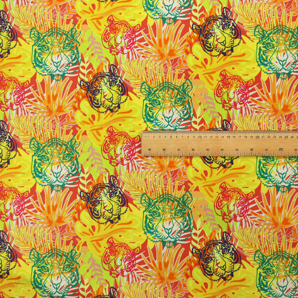 The image features a vibrant, repeating tropical pattern set against a bright yellow and orange background. The design is filled with stylized jungle foliage, including overlapping palm fronds and leaves. Interspersed throughout the pattern are illustrative tiger faces rendered in different colours, including striking shades of green, dark blue, and pinkish-red.   