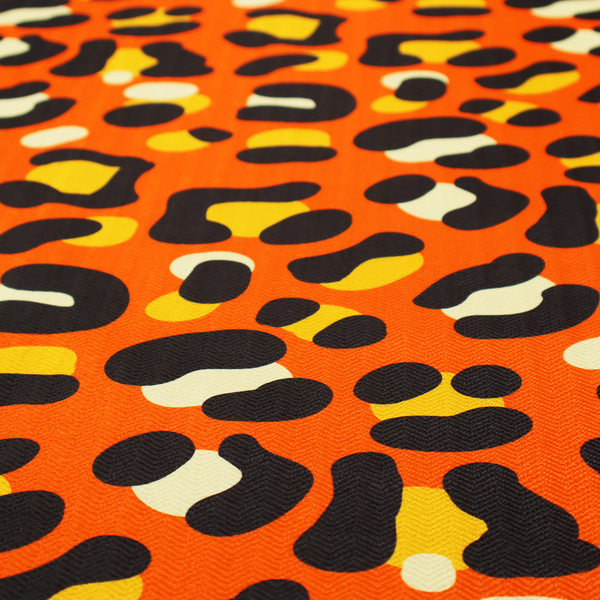 The image features a bold leopard print upholstery fabric in a vibrant orange background with black spots featuring yellow and cream highlights.   