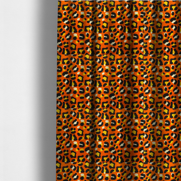The fabric used to create these made-to-measure curtains features a bold leopard print upholstery fabric in a vibrant orange background with black spots featuring yellow and cream highlights.   