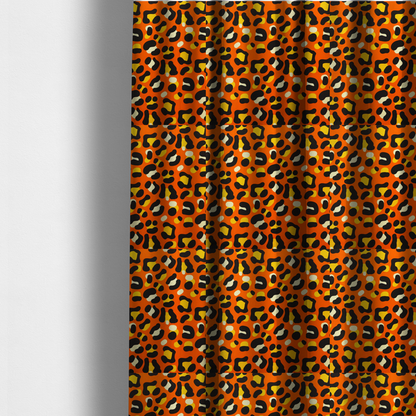The fabric used to create these made-to-measure curtains features a bold leopard print upholstery fabric in a vibrant orange background with black spots featuring yellow and cream highlights.   