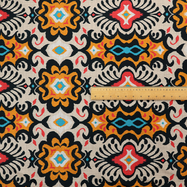 The image features a vibrant, symmetrical ikat-style pattern set against a light background. The design includes elaborate floral motifs and geometric shapes in striking shades of black, orange, yellow, bright red, and turquoise.   