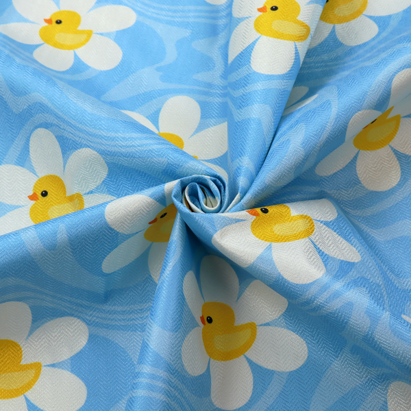 The image features a repeating pattern of white daisies with yellow centres shaped like little rubber ducks, all set against a wavy blue background.   
