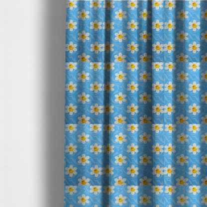 the fabric used to create these made-to-measure curtains features a repeating pattern of white daisies with yellow centres shaped like little rubber ducks, all set against a wavy blue background.   