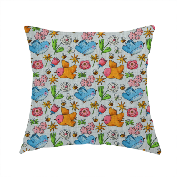 The fabric used to create this handmade cushion features a playful, repeating pattern of whimsical birds, flowers, and bees set against a light background. The whimsical design includes blue and orange-yellow birds, pink and white flowers, and tiny buzzing bees.