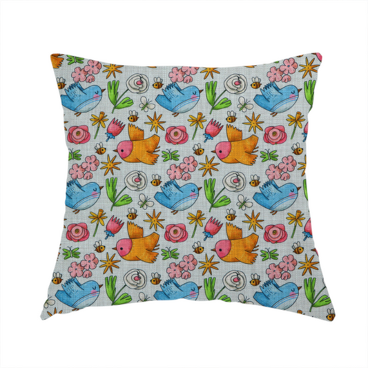 The fabric used to create this handmade cushion features a playful, repeating pattern of whimsical birds, flowers, and bees set against a light background. The whimsical design includes blue and orange-yellow birds, pink and white flowers, and tiny buzzing bees.