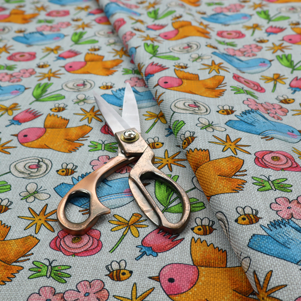 The image features a playful, repeating pattern of whimsical birds, flowers, and bees set against a light background. The whimsical design includes blue and orange-yellow birds, pink and white flowers, and tiny buzzing bees.