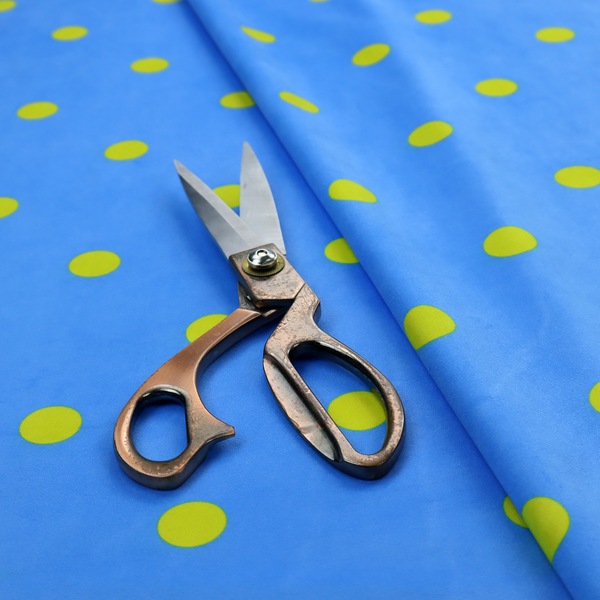 A blue fabric pattern featuring evenly spaced yellow polka dots arranged in horizontal and vertical rows.
