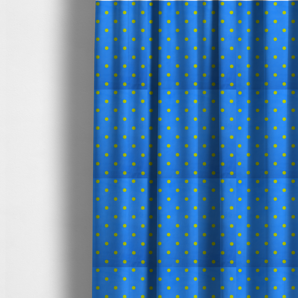 The fabric used to create these made-to-measure curtains is a blue fabric pattern featuring evenly spaced yellow polka dots arranged in horizontal and vertical rows.