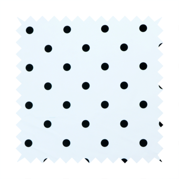 A white fabric pattern featuring evenly spaced black polka dots arranged in horizontal and vertical rows.