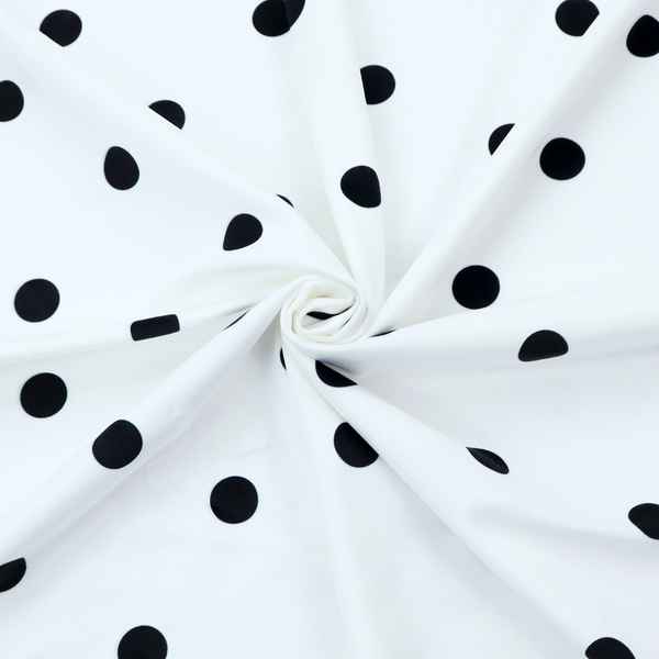 A white fabric pattern featuring evenly spaced black polka dots arranged in horizontal and vertical rows.