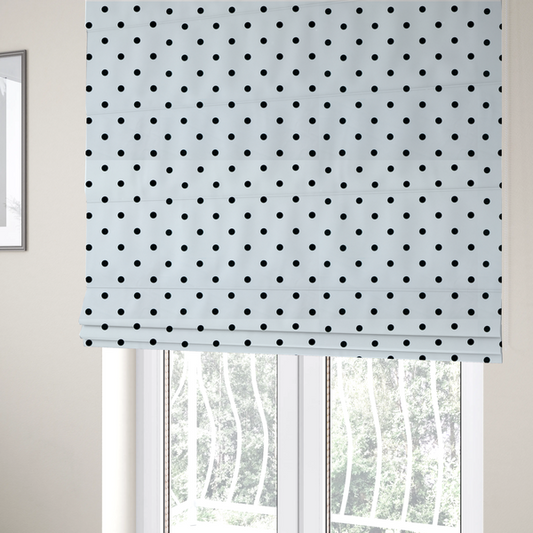 The fabric used to create these Roman blinds is a white fabric pattern featuring evenly spaced black polka dots arranged in horizontal and vertical rows.