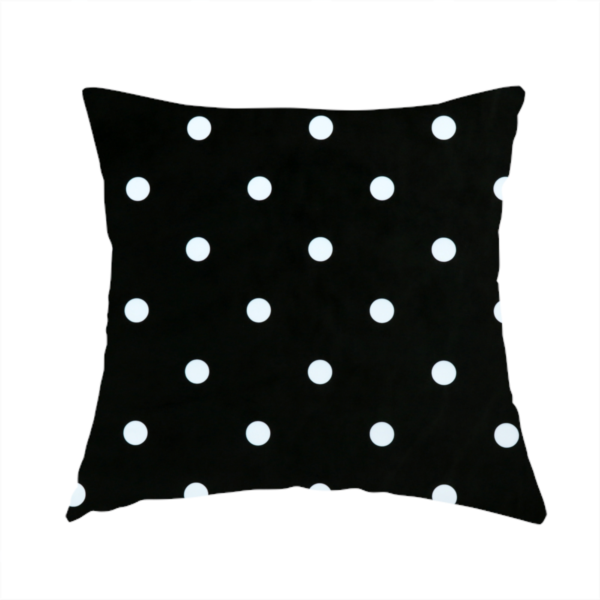 The fabric used to create this handmade cushion is a black fabric pattern featuring evenly spaced white polka dots arranged in horizontal and vertical rows.