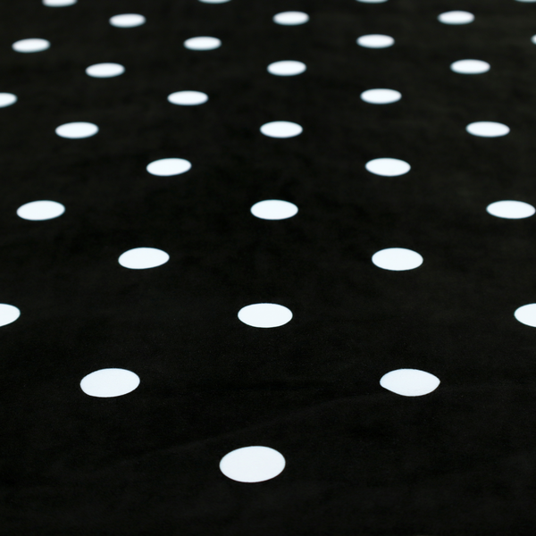 A black fabric pattern featuring evenly spaced white polka dots arranged in horizontal and vertical rows.