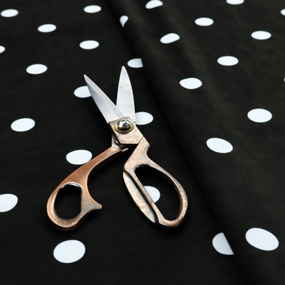 A black fabric pattern featuring evenly spaced white polka dots arranged in horizontal and vertical rows.