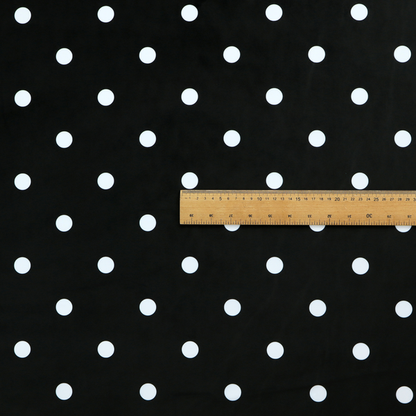 A black fabric pattern featuring evenly spaced white polka dots arranged in horizontal and vertical rows.