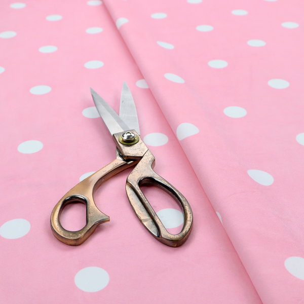 A pink fabric pattern featuring evenly spaced white polka dots arranged in horizontal and vertical rows.