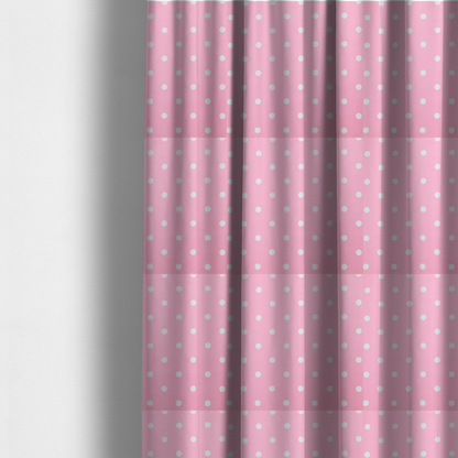 The fabric used to create these made-to-measure curtains is a pink fabric pattern featuring evenly spaced white polka dots arranged in horizontal and vertical rows.