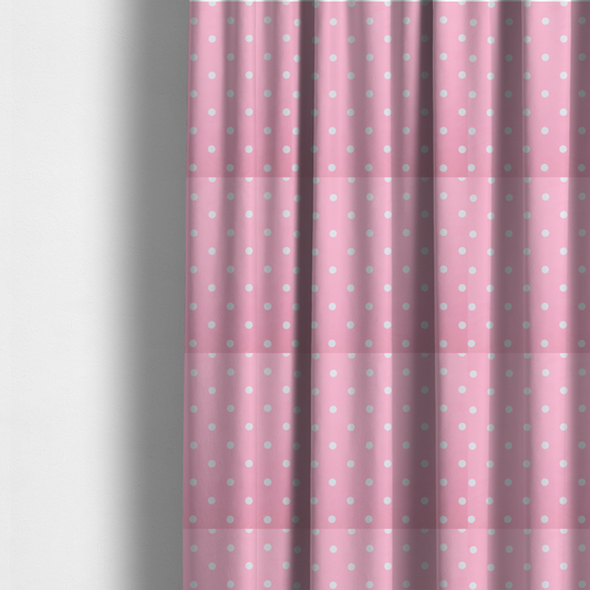 The fabric used to create these made-to-measure curtains is a pink fabric pattern featuring evenly spaced white polka dots arranged in horizontal and vertical rows.