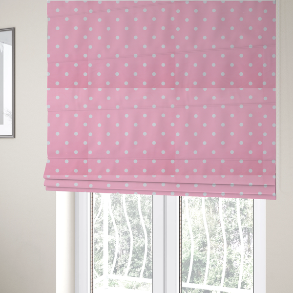 The fabric used to create these Roman blinds is a pink fabric pattern featuring evenly spaced white polka dots arranged in horizontal and vertical rows.