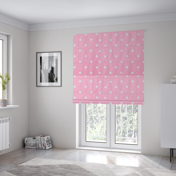 The fabric used to create these Roman blinds is a pink fabric pattern featuring evenly spaced white polka dots arranged in horizontal and vertical rows.