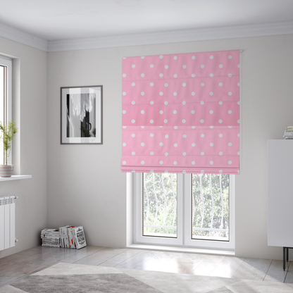 The fabric used to create these Roman blinds is a pink fabric pattern featuring evenly spaced white polka dots arranged in horizontal and vertical rows.
