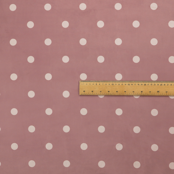 A dusty rose or mauve fabric pattern featuring evenly spaced off-white polka dots arranged in horizontal and vertical rows.
