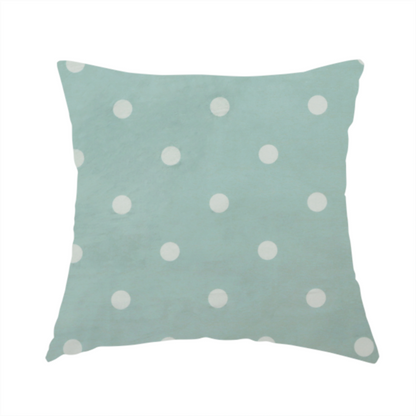 The fabric used to create this handmade cushion is a sage green or pale teal fabric pattern featuring evenly spaced white polka dots arranged in horizontal and vertical rows.
