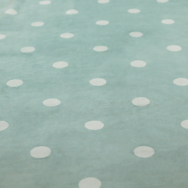 A sage green or pale teal fabric pattern featuring evenly spaced white polka dots arranged in horizontal and vertical rows.