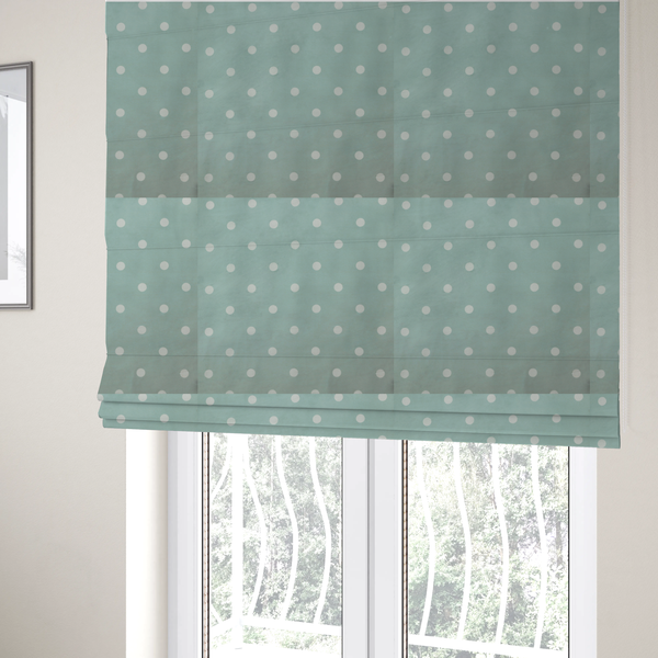 The fabric used to create these Roman blinds is a sage green or pale teal fabric pattern featuring evenly spaced white polka dots arranged in horizontal and vertical rows.