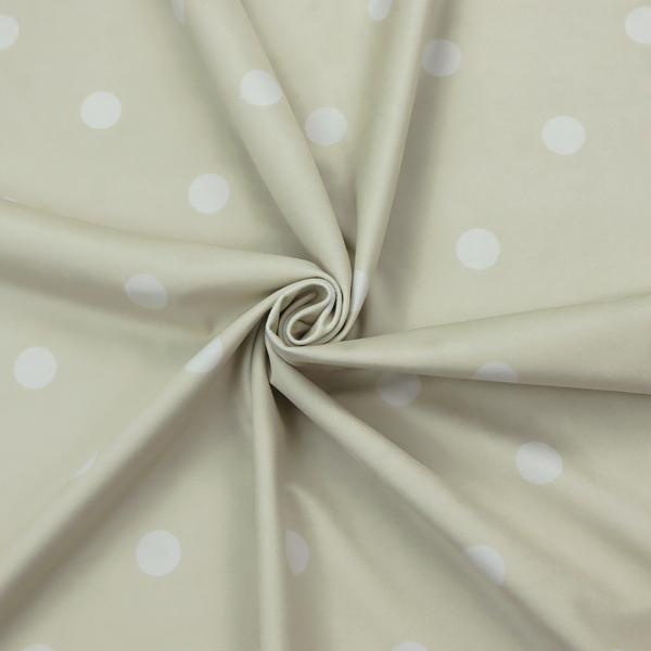 A cream or beige fabric pattern featuring evenly spaced white polka dots arranged in horizontal and vertical rows.