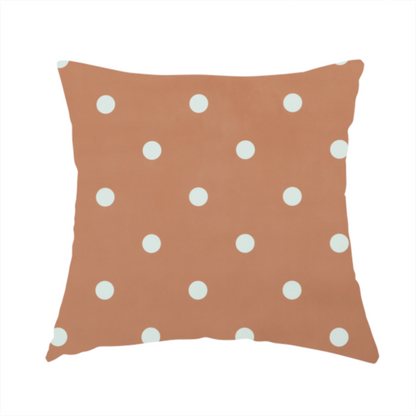 The fabric used to create this handmade cushion is a terracotta or warm brown fabric pattern featuring evenly spaced white polka dots arranged in horizontal and vertical rows.