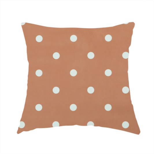 The fabric used to create this handmade cushion is a terracotta or warm brown fabric pattern featuring evenly spaced white polka dots arranged in horizontal and vertical rows.