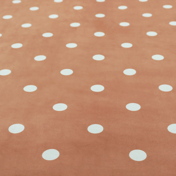 A terracotta or warm brown fabric pattern featuring evenly spaced white polka dots arranged in horizontal and vertical rows.