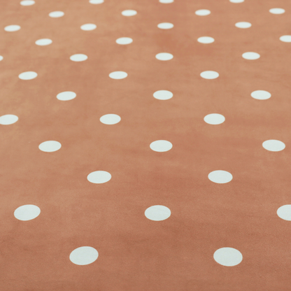 A terracotta or warm brown fabric pattern featuring evenly spaced white polka dots arranged in horizontal and vertical rows.