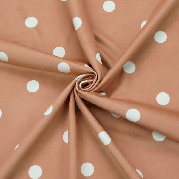 A terracotta or warm brown fabric pattern featuring evenly spaced white polka dots arranged in horizontal and vertical rows.