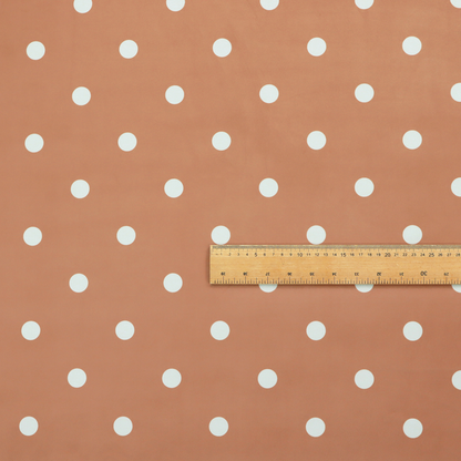 A terracotta or warm brown fabric pattern featuring evenly spaced white polka dots arranged in horizontal and vertical rows.