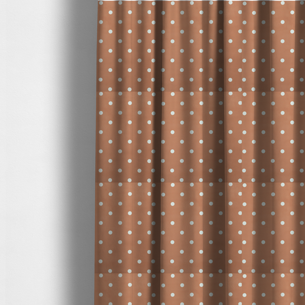 The fabric used to create these made to-measure curtains is a terracotta or warm brown fabric pattern featuring evenly spaced white polka dots arranged in horizontal and vertical rows.